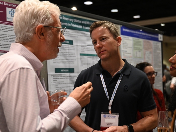 To men talking during poster session